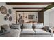 Cozy living room features exposed wooden beams, comfortable seating, and stylish decor on the walls at 3593 S Gibralter Cir, Aurora, CO 80013