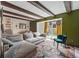 Spacious living room with exposed wooden beams, green accent wall, sliding door access to backyard at 3593 S Gibralter Cir, Aurora, CO 80013