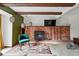 Inviting living room features a brick fireplace, wooden beams, stylish decor, and comfortable seating at 3593 S Gibralter Cir, Aurora, CO 80013