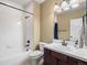 Neat bathroom with a white tub, toilet, white-tile backsplash and dark wood cabinets at 8099 Sabino Ln, Castle Rock, CO 80108