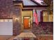 A warm orange front door is flanked by sconces and an American flag is shown at 8099 Sabino Ln, Castle Rock, CO 80108