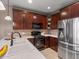 A kitchen area featuring stainless steel appliances and dark brown cabinets, plus white countertops and stylish backsplash at 8099 Sabino Ln, Castle Rock, CO 80108