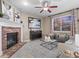 A beautiful living room area with fireplace, neutral walls, big windows with sunset view, and decorative modern art at 8099 Sabino Ln, Castle Rock, CO 80108
