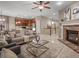 Open concept living space with brick fireplace, neutral furniture, and seamless flow to kitchen and dining at 8099 Sabino Ln, Castle Rock, CO 80108