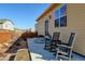 Backyard featuring a patio with rocking chairs, a well-maintained wooden fence, and landscaped areas at 1799 Jade Ave, Brighton, CO 80603