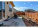 Backyard featuring a patio area with rocking chairs, planters, and a well-maintained fence at 1799 Jade Ave, Brighton, CO 80603