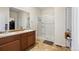 Bathroom featuring a double sink vanity, a glass-enclosed shower, and earth-tone flooring at 1799 Jade Ave, Brighton, CO 80603