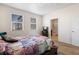 Bright bedroom featuring dual windows and an ensuite bathroom, providing comfort and privacy at 1799 Jade Ave, Brighton, CO 80603