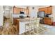 Bright kitchen features wood cabinets, an island with seating, and modern appliances at 1799 Jade Ave, Brighton, CO 80603