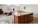 Open-concept kitchen with island, seamlessly flowing into the living and dining areas at 1799 Jade Ave, Brighton, CO 80603