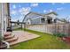 Landscaped backyard featuring a stone patio, lush lawn, privacy fence, and beautiful flowers at 15524 E 115Th Ave, Commerce City, CO 80022