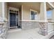 Inviting front porch with stone accents, a security camera, and stylish lighting at 15524 E 115Th Ave, Commerce City, CO 80022