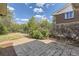 Spacious backyard featuring stone tiled patio, mature trees, and privacy shrubs at 1926 S Yates St, Denver, CO 80219