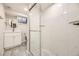 Modern bathroom featuring glass shower, updated vanity, and marble-like tiled walls at 1926 S Yates St, Denver, CO 80219