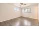 Neutral bedroom features gray wood-look flooring, a ceiling fan, and two windows at 1926 S Yates St, Denver, CO 80219