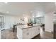Open concept kitchen with large island, modern appliances, and seamless flow to living area at 1926 S Yates St, Denver, CO 80219