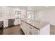 Modern kitchen boasts white cabinetry, stainless steel appliances, an island and hardwood floors at 1926 S Yates St, Denver, CO 80219