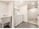 Clean laundry room with utility sink, washer, dryer, and adjacent room access at 1926 S Yates St, Denver, CO 80219