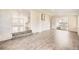 Bright, open living area with white-washed brick and newly installed wood-look flooring at 1926 S Yates St, Denver, CO 80219