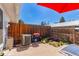 Enclosed backyard with a BBQ grill, AC condenser, small planter, wood fence, and patio at 13977 E Bails Pl, Aurora, CO 80012