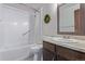 Bright bathroom features a shower and tub combination with a modern single sink vanity at 13977 E Bails Pl, Aurora, CO 80012