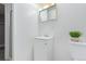 Bright, all-white bathroom with a single sink vanity, mirrored medicine cabinet, and neutral accents at 13977 E Bails Pl, Aurora, CO 80012