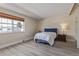 Bright bedroom featuring a large window, white walls, and light wood floors at 13977 E Bails Pl, Aurora, CO 80012