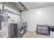 Functional laundry room with gray washer and dryer, shelving, and hot water tank at 13977 E Bails Pl, Aurora, CO 80012