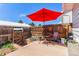 Cozy patio with an umbrella, small table and chairs, a wood fence, and some foliage at 13977 E Bails Pl, Aurora, CO 80012