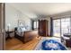 Spacious bedroom boasts a wooden sleigh bed, a blue patterned rug, and balcony access for a bright and airy feel at 3 Pinyon Pine Rd, Littleton, CO 80127