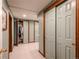 Hallway with multiple doors, including a closet, featuring wood trim and tile floors at 3 Pinyon Pine Rd, Littleton, CO 80127