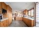 Bright kitchen with wood cabinets, stainless steel appliances, and view into the dining area at 3 Pinyon Pine Rd, Littleton, CO 80127