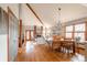 Open-concept living and dining area with vaulted ceilings, brick fireplace, and wood floors at 3 Pinyon Pine Rd, Littleton, CO 80127