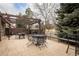 Outdoor patio with a pergola, black metal table and chairs, and a grill at 3 Pinyon Pine Rd, Littleton, CO 80127