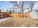 Fenced backyard with lawn and mature trees offering shade and privacy at 2565 Pierce St, Lakewood, CO 80214