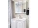 Bathroom featuring a white vanity with a mirror, modern fixtures, and a shower with marble-look tile at 2565 Pierce St, Lakewood, CO 80214