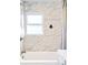 Bathroom featuring marble-look tile, a shower, a window, and modern fixtures at 2565 Pierce St, Lakewood, CO 80214