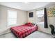 Bedroom with a red and black plaid bed, two windows, and neutral walls at 2565 Pierce St, Lakewood, CO 80214