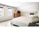 Comfortable bedroom featuring wood-look flooring, two windows, and a dresser with a television on top at 2565 Pierce St, Lakewood, CO 80214