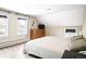 Bedroom featuring a wooden dresser, TV, and three windows at 2565 Pierce St, Lakewood, CO 80214