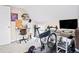 Home gym with desk, shelving unit, bicycle on trainer, and ample natural light at 2565 Pierce St, Lakewood, CO 80214