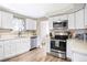 Bright kitchen featuring stainless steel appliances, white cabinets and countertops and modern fixtures at 2565 Pierce St, Lakewood, CO 80214