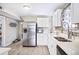 Modern kitchen with stainless steel refrigerator, white cabinets, and a double basin sink at 2565 Pierce St, Lakewood, CO 80214