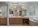 Bathroom vanity with a large mirror, custom cabinets and fixtures, and natural light at 392 Starmine Pl, Castle Rock, CO 80108