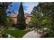 Lush lawn and garden leading to a multi-story home with large windows and stucco exterior at 392 Starmine Pl, Castle Rock, CO 80108