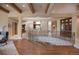 Open living area with hardwood floors, beam ceiling and an iron railing staircase at 392 Starmine Pl, Castle Rock, CO 80108
