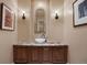 Stylish powder room features a decorative mirror, wall sconces and custom vanity at 392 Starmine Pl, Castle Rock, CO 80108