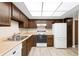 Classic kitchen with white appliances, laminate countertops, and dark wood cabinetry at 14091 E Marina Dr # 308, Aurora, CO 80014