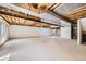Unfinished basement space with white walls and visible ceiling beams at 13515 Milwaukee Ct, Thornton, CO 80241