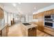 Bright kitchen featuring hardwood floors, a granite island, and stainless steel appliances at 13515 Milwaukee Ct, Thornton, CO 80241